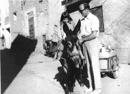 NiÃ±a sobre un burro junto a su padre. Morata de Jiloca.